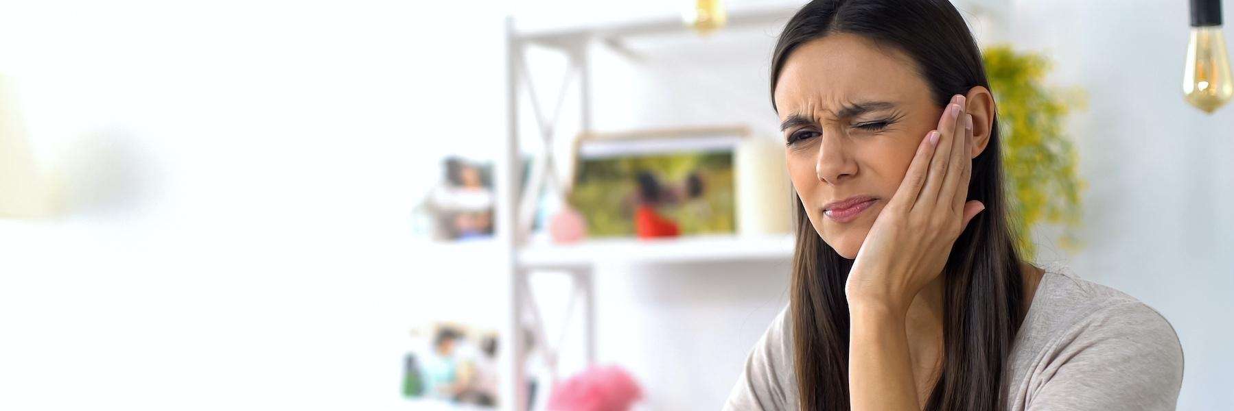 woman in pain holding her cheek